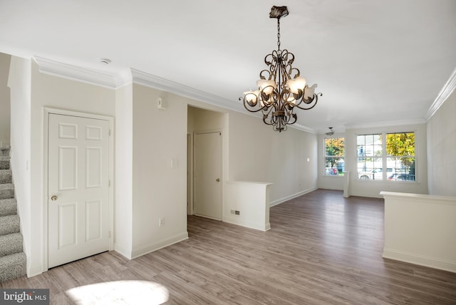 interior space with ceiling fan with notable chandelier, light wood-type flooring, and crown molding