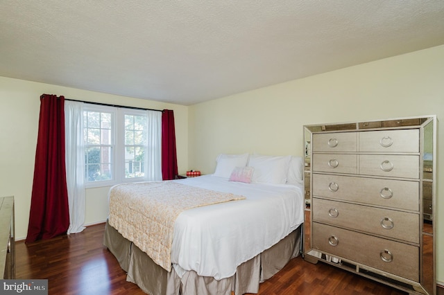 bedroom featuring a textured ceiling and dark hardwood / wood-style floors