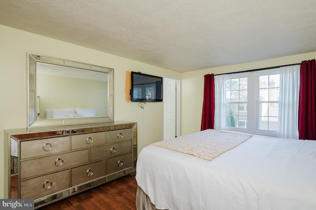 bedroom with dark wood-type flooring and a textured ceiling