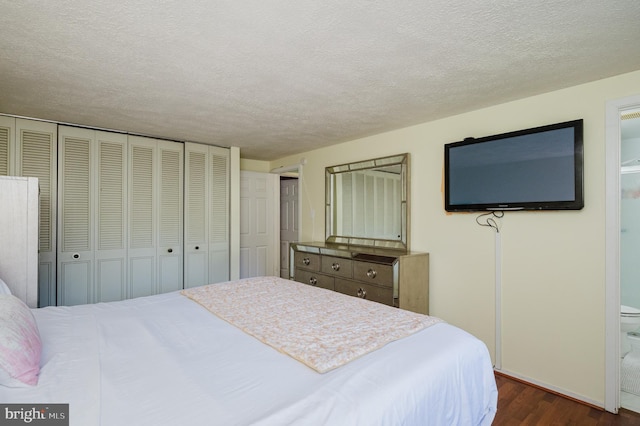 bedroom featuring a textured ceiling, ensuite bathroom, and dark hardwood / wood-style flooring