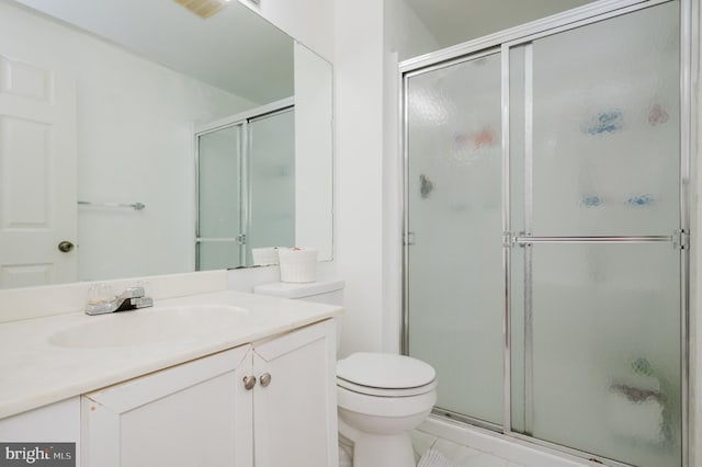 bathroom featuring vanity, toilet, tile patterned floors, and a shower with door