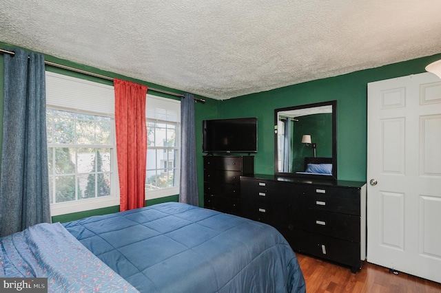 bedroom with dark wood-type flooring and a textured ceiling