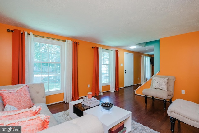 living room featuring a healthy amount of sunlight, a textured ceiling, and dark hardwood / wood-style flooring