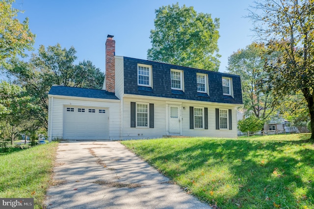 colonial home featuring a front yard and a garage