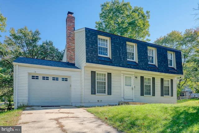 colonial house featuring a garage and a front lawn