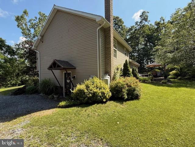 48 W 3rd St, Everett, PA 15537 - view of side of home featuring a chimney and a lawn