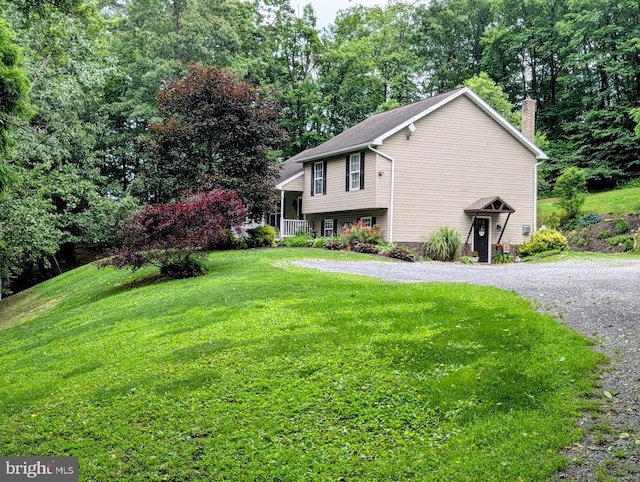 48 W 3rd St, Everett, PA 15537 - view of front of property with a chimney, a front yard, gravel driveway, and view of wooded area