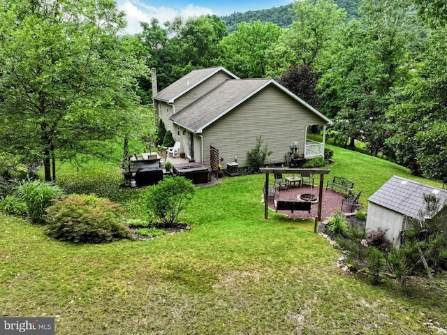 48 W 3rd St, Everett, PA 15537 - view of side of property with an outdoor fire pit, a wooden deck, a yard, a view of trees, and a shingled roof