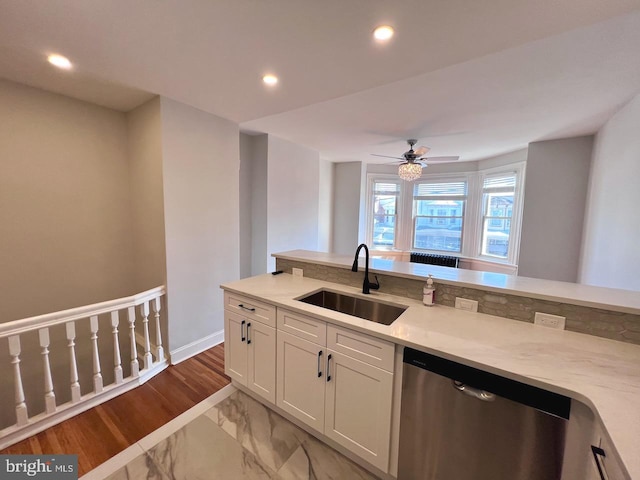 kitchen featuring light stone countertops, white cabinets, ceiling fan, sink, and dishwasher