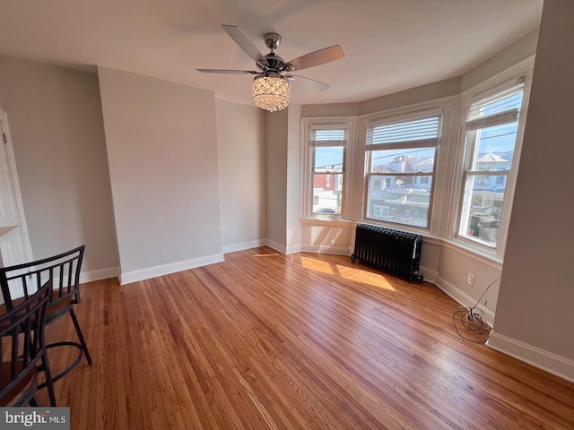 interior space with radiator, ceiling fan, and light wood-type flooring