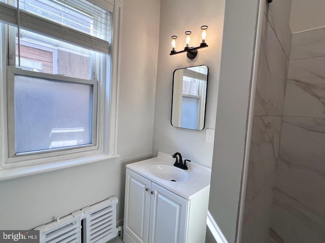 bathroom with vanity, a tile shower, and radiator