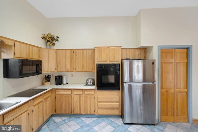 kitchen featuring black appliances, light brown cabinetry, and sink