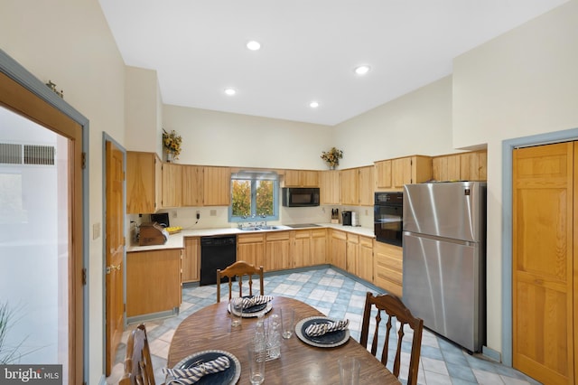 kitchen featuring sink, a towering ceiling, black appliances, and light tile patterned floors