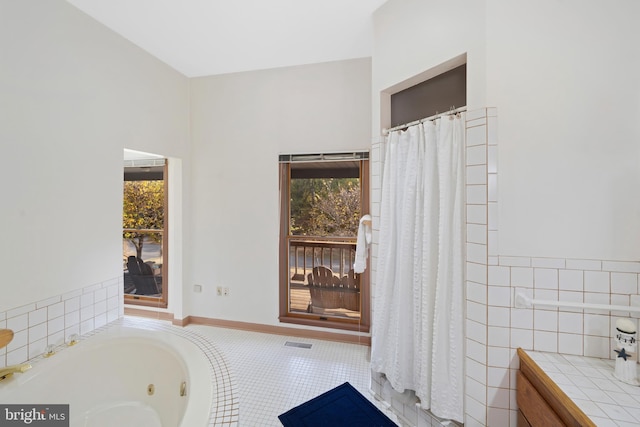 bathroom with a tub to relax in and tile patterned floors