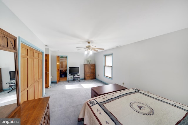 bedroom with a closet, light colored carpet, and ceiling fan