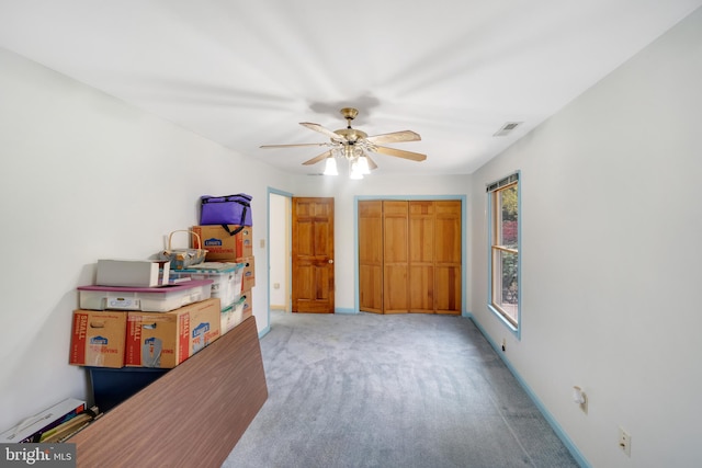 bedroom featuring light colored carpet, a closet, and ceiling fan