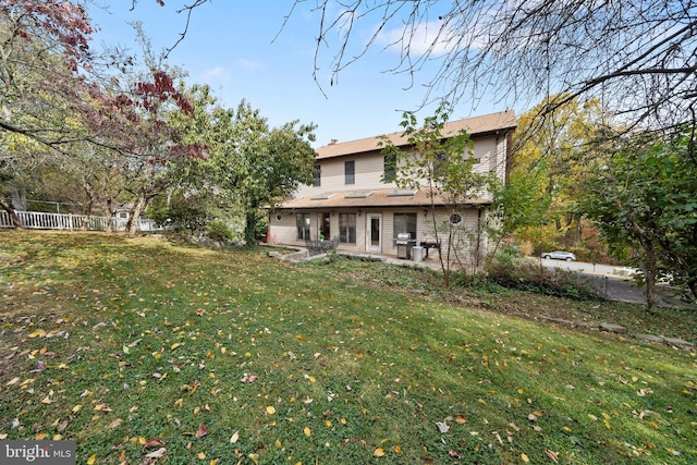 rear view of house featuring a patio and a lawn