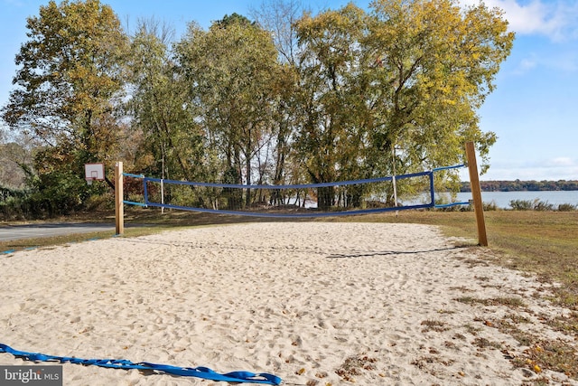 view of property's community featuring volleyball court and a water view