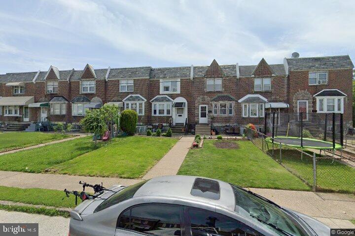 townhome / multi-family property with a trampoline and a front lawn