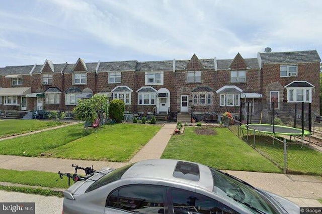 view of property with a trampoline and a front yard