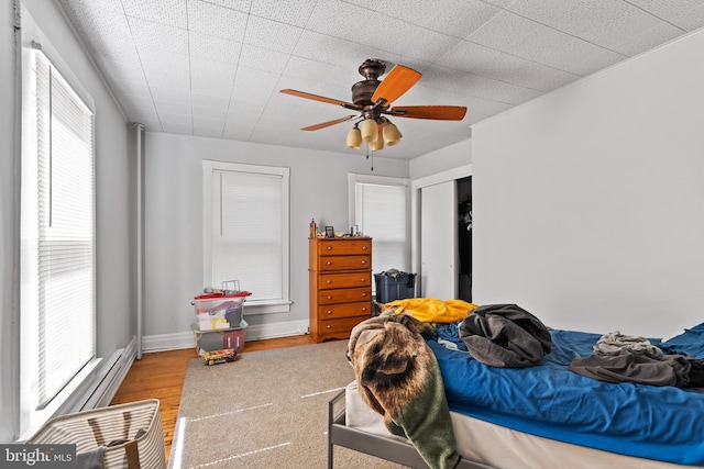 bedroom featuring light hardwood / wood-style flooring, multiple windows, and ceiling fan