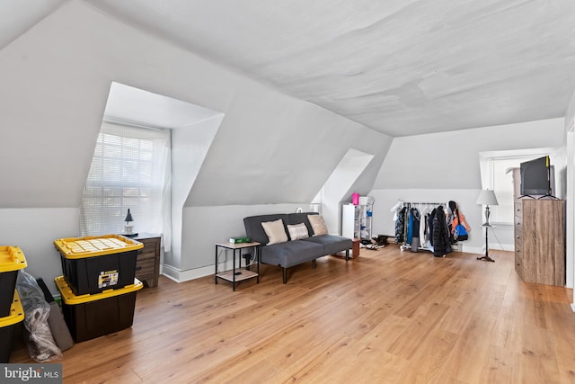 additional living space featuring light hardwood / wood-style flooring and vaulted ceiling