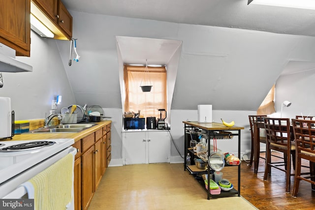 kitchen featuring lofted ceiling, hardwood / wood-style floors, white electric range, and sink