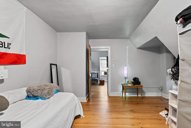 bedroom with hardwood / wood-style flooring and lofted ceiling