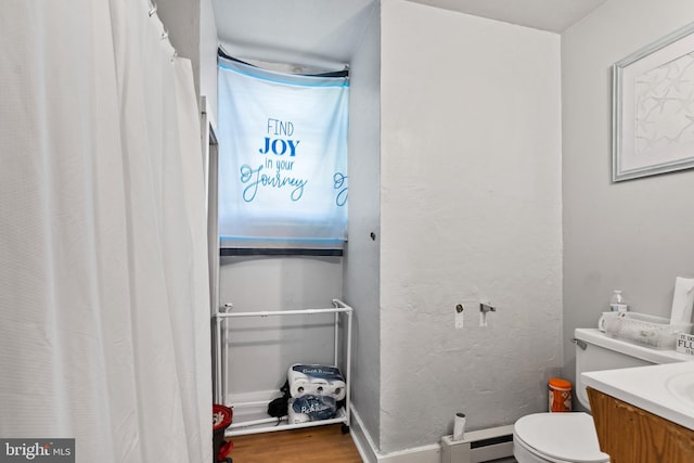 bathroom featuring vanity, hardwood / wood-style floors, toilet, and a baseboard radiator