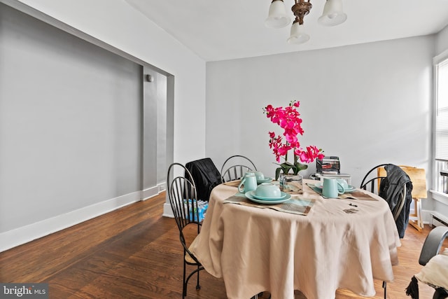 dining area featuring wood-type flooring and an inviting chandelier