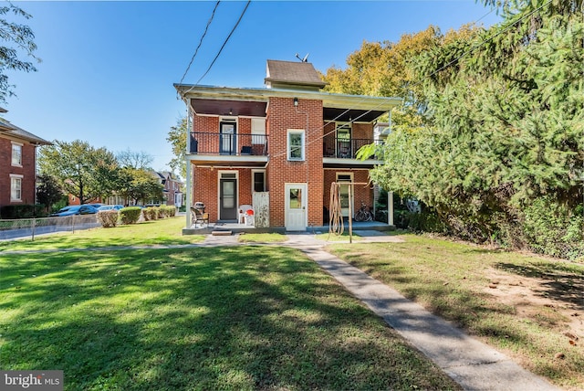 view of front of home featuring a patio, a front lawn, and a balcony