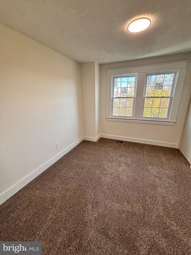 carpeted spare room featuring a textured ceiling