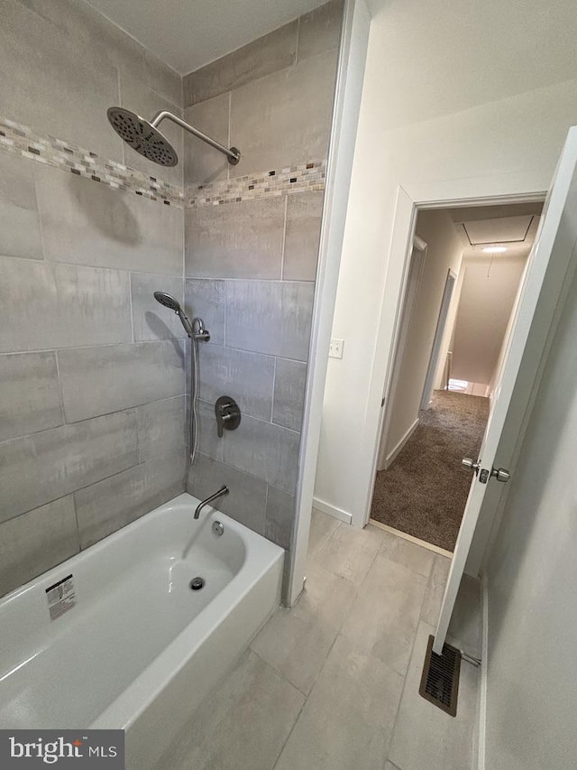 bathroom with tiled shower / bath and tile patterned floors