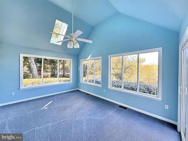 unfurnished sunroom featuring vaulted ceiling with skylight, a healthy amount of sunlight, and ceiling fan