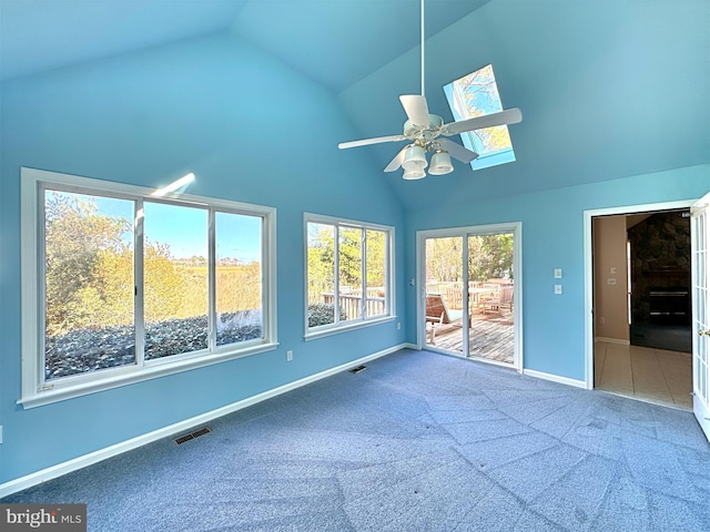 unfurnished sunroom with ceiling fan and vaulted ceiling with skylight