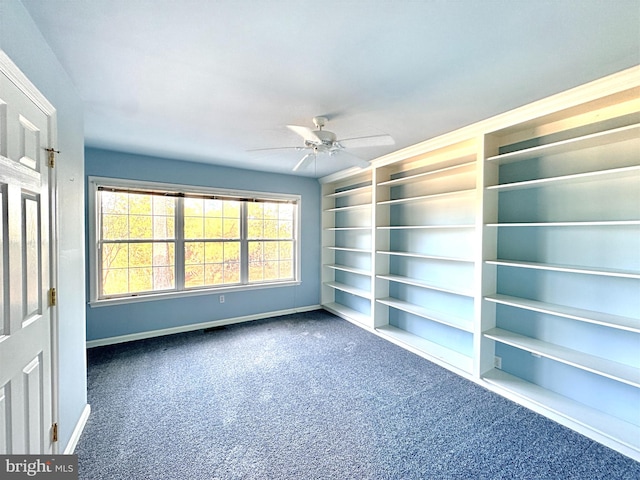 empty room featuring dark carpet and ceiling fan