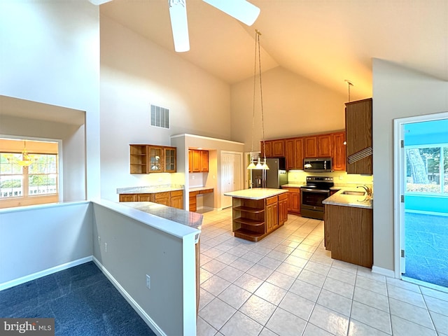 kitchen featuring appliances with stainless steel finishes, a skylight, a kitchen island, pendant lighting, and high vaulted ceiling