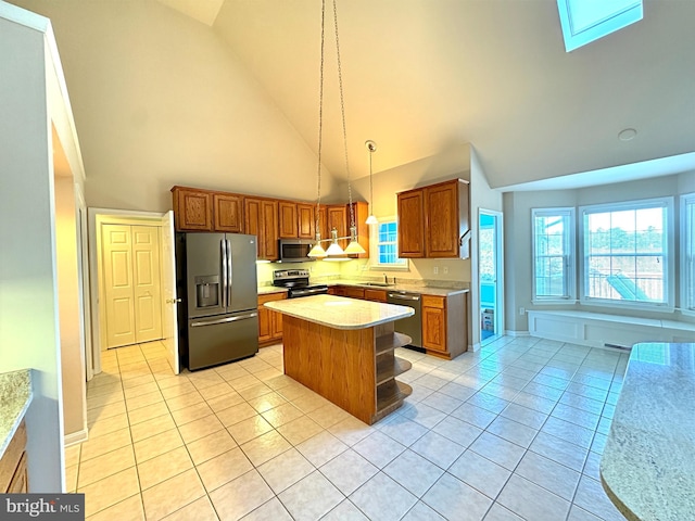 kitchen featuring sink, a center island, stainless steel appliances, decorative light fixtures, and high vaulted ceiling