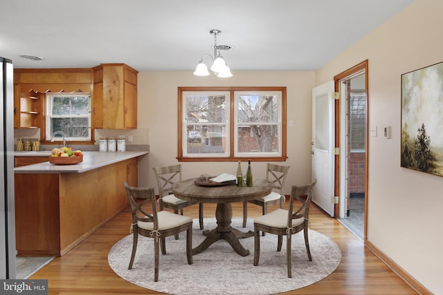 dining room featuring light hardwood / wood-style floors, a notable chandelier, and sink