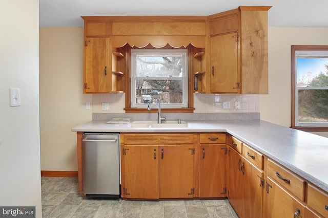 kitchen featuring tasteful backsplash, dishwasher, and sink