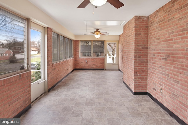 unfurnished sunroom with ceiling fan and a wealth of natural light