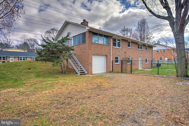 rear view of property with a garage and a lawn