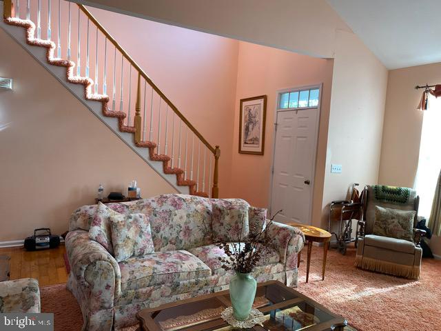 living room with hardwood / wood-style flooring and vaulted ceiling