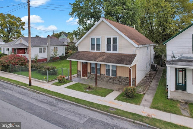 view of front of house featuring a front yard and central AC unit