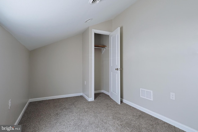 unfurnished bedroom with a closet, carpet, and lofted ceiling