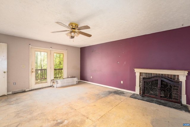 unfurnished living room with ceiling fan, a textured ceiling, and a fireplace