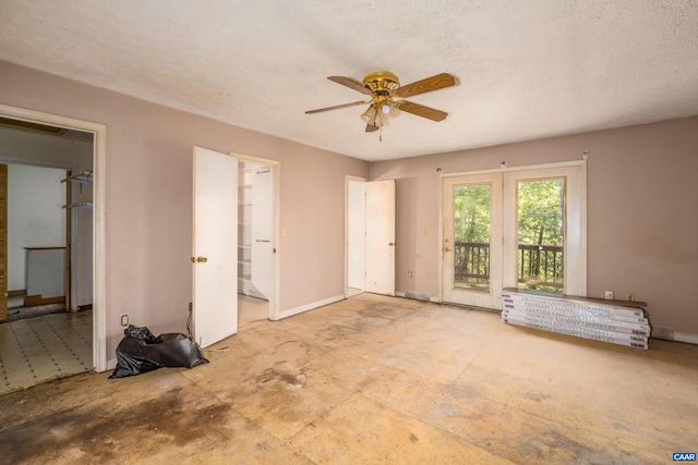 empty room with ceiling fan and a textured ceiling