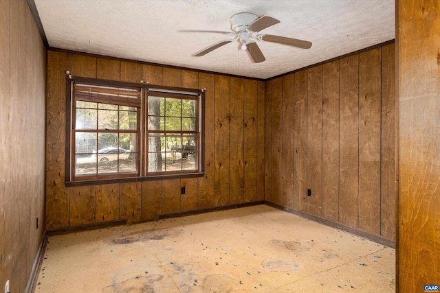 spare room featuring wooden walls and ceiling fan