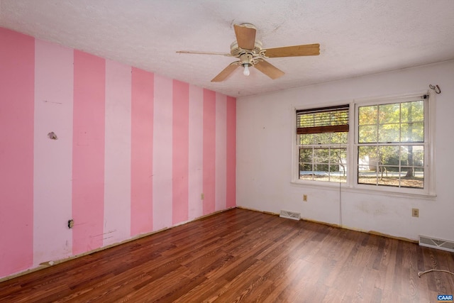 empty room featuring ceiling fan, hardwood / wood-style floors, and a textured ceiling