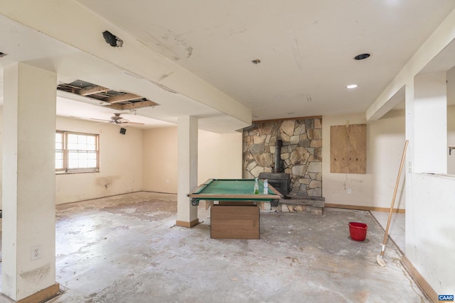 game room featuring ceiling fan, billiards, and a wood stove